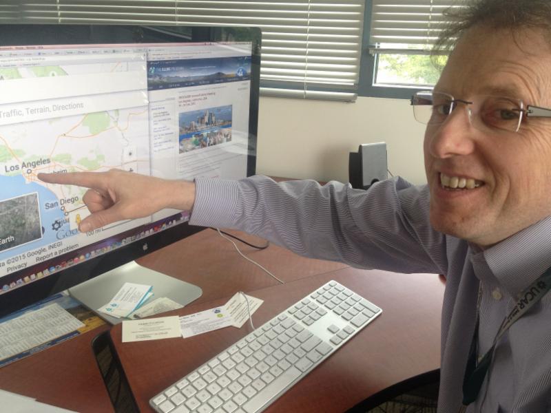 Dr. Tony Murphy pointing to Los Angeles, CA on a map on his computer screen.